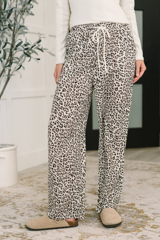Woman wearing Wania Leopard Drawstring Pants, cream base with wide leg silhouette and high-waisted fit.