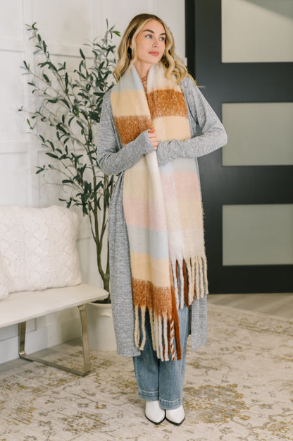 Model wearing the Wanderlust Wrap Oversized Plaid Fringe Scarf in light brown.