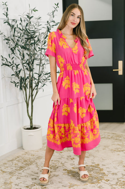Full body view of model wearing the Lainey V-Neck Dress in fuchsia, highlighting the flutter sleeves, gathered tiers, and flowing woven fabric.