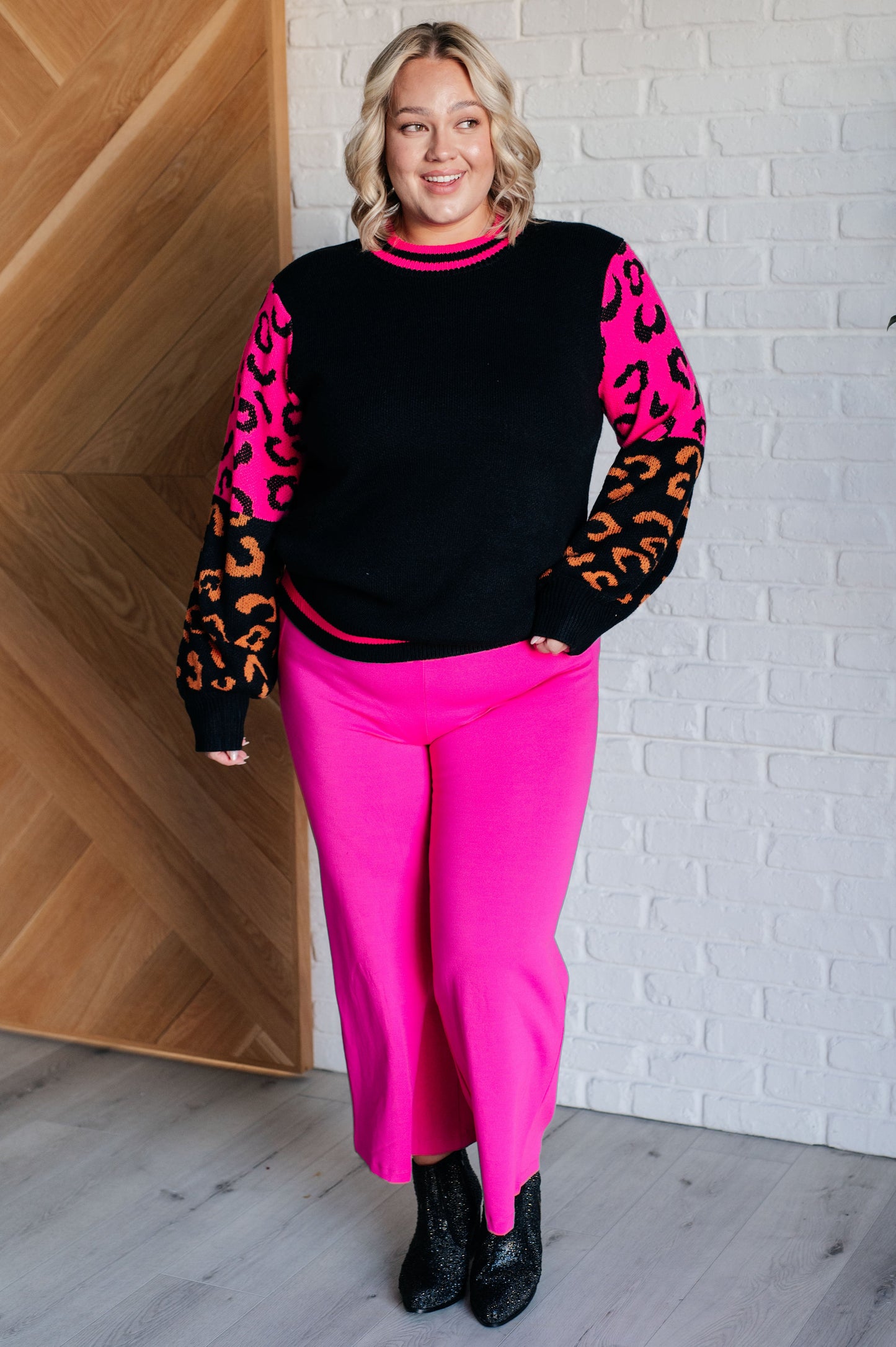 Women's animal print sweater with color block design and pink contrast details.