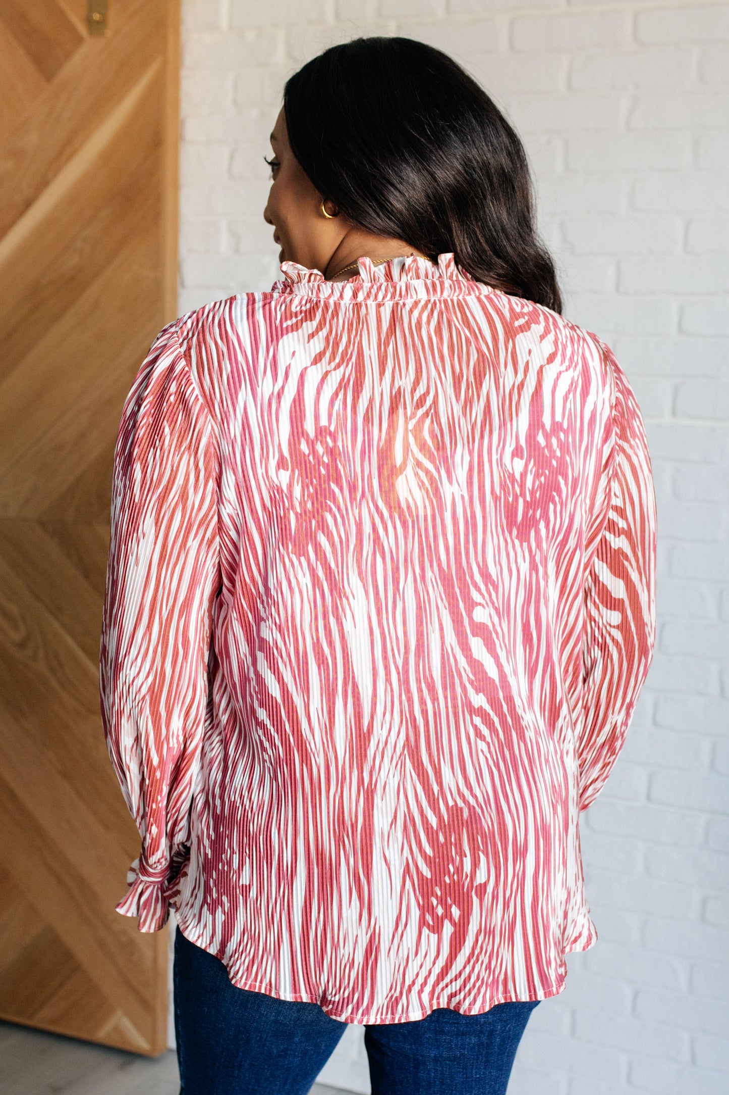 Margo Animal Print Blouse made from poly satin with a V-neckline, neck tie, playful poet sleeves, frill details, and a plissé texture.