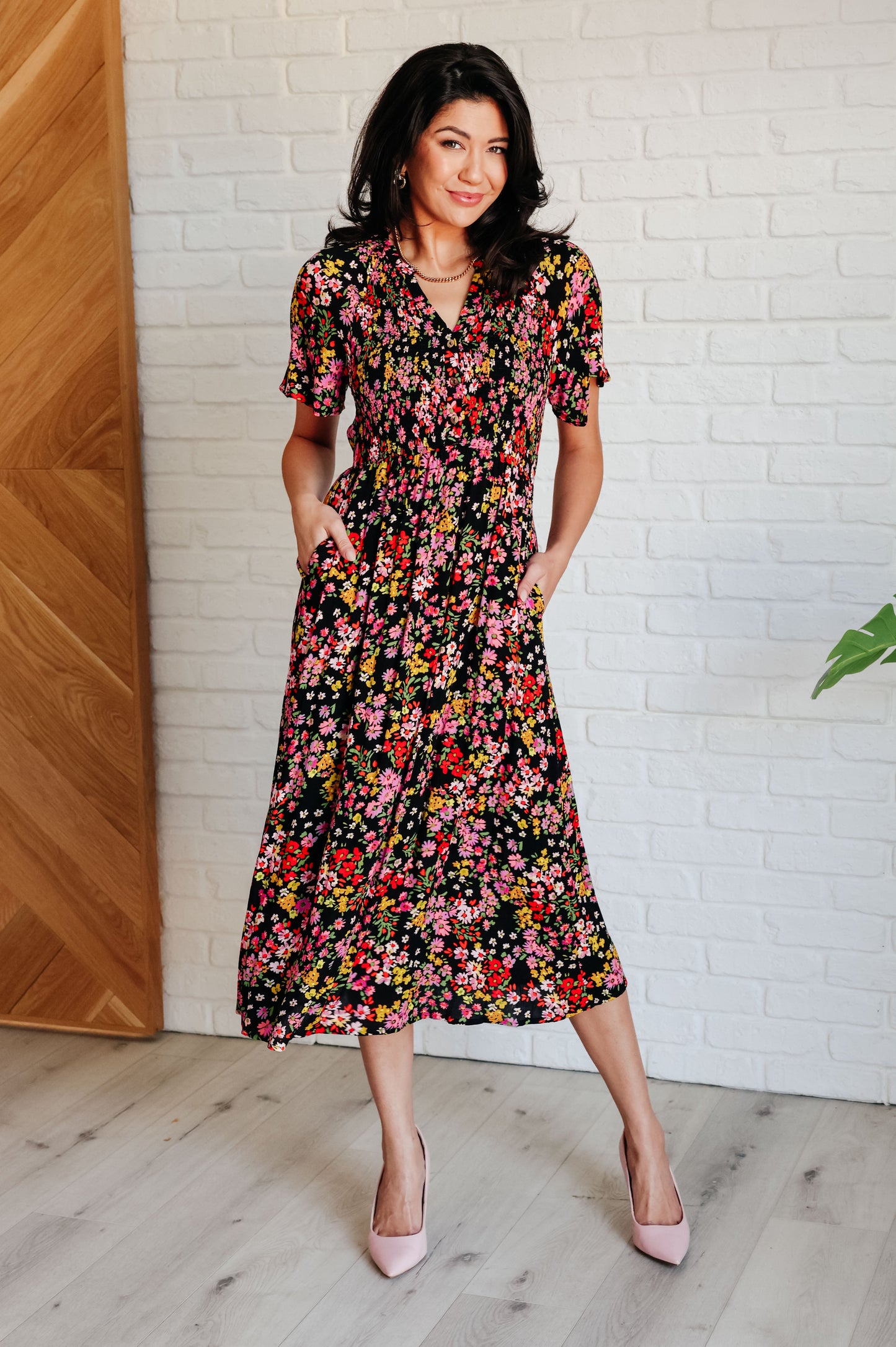 Floral V-neck button-up dress with flutter sleeves, a smocked elastic bodice, an elastic waistline, and functional side pockets.