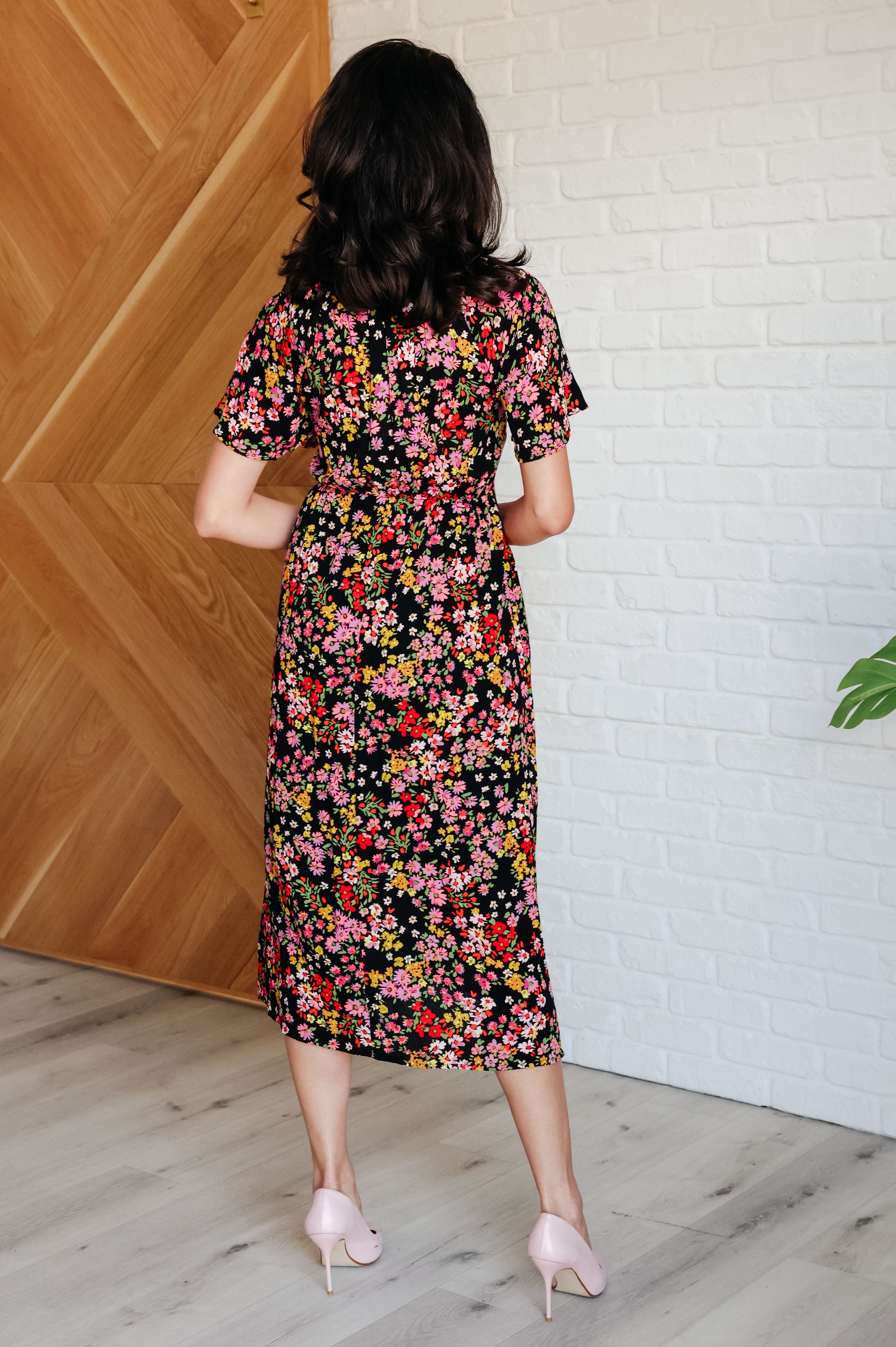 Floral V-neck button-up dress with flutter sleeves, a smocked elastic bodice, an elastic waistline, and functional side pockets.