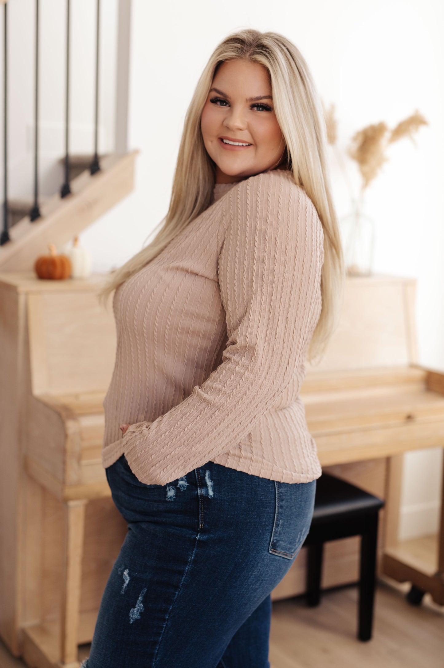 Side profile of plus size model in Marlo Cable Detail Top, beige knit with raglan sleeve detail
