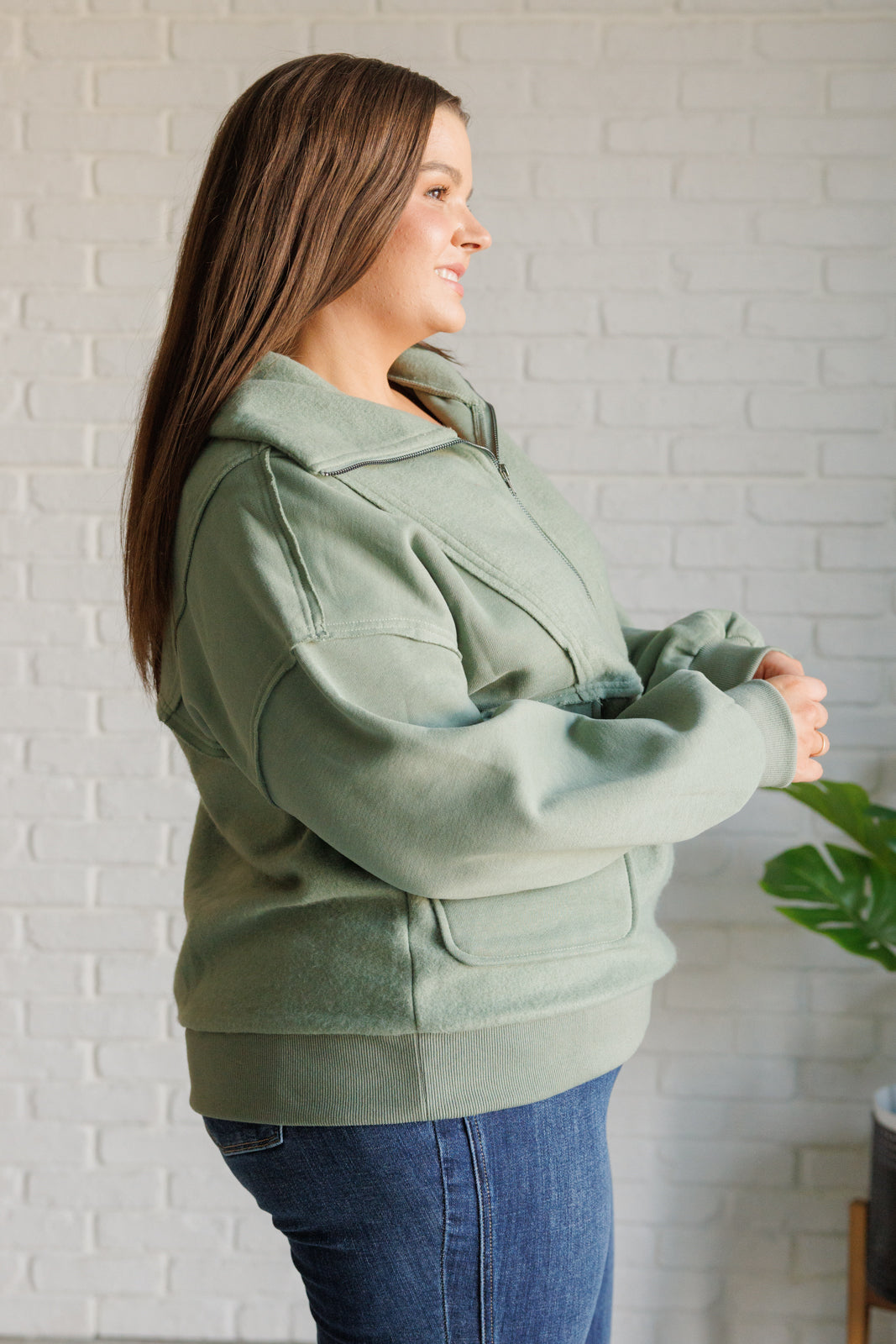 Sage fleece pullover with a collared neckline, half zipper, snap pockets, and raw edge details.