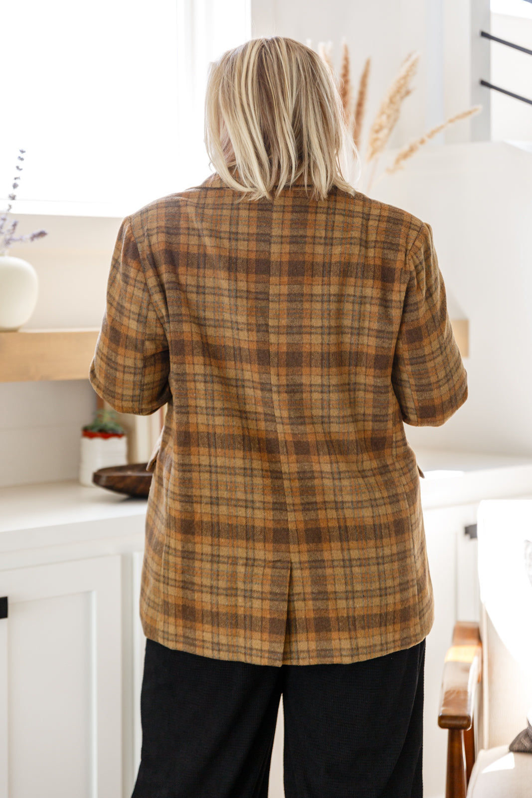 Brown plaid blazer with notched lapels, single button closure, and flap pockets. Features shoulder pads, a fully lined interior, and a tailored, relaxed fit.