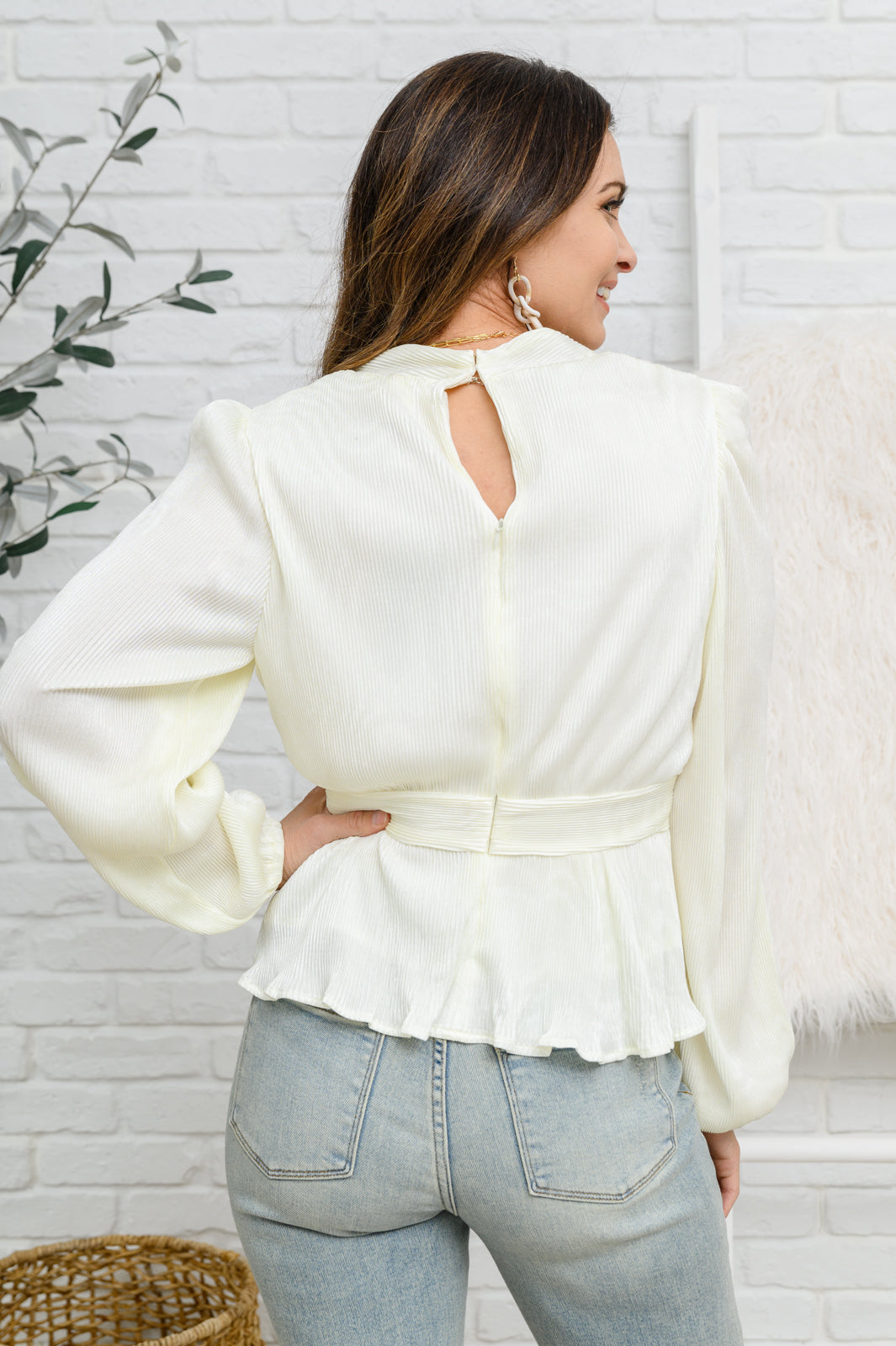 Women's Long Sleeve V Neck Blouse in White with plissé fabric, V-neckline, peplum waist, balloon sleeves, and back zipper closure. Perfect for formal or casual occasions.