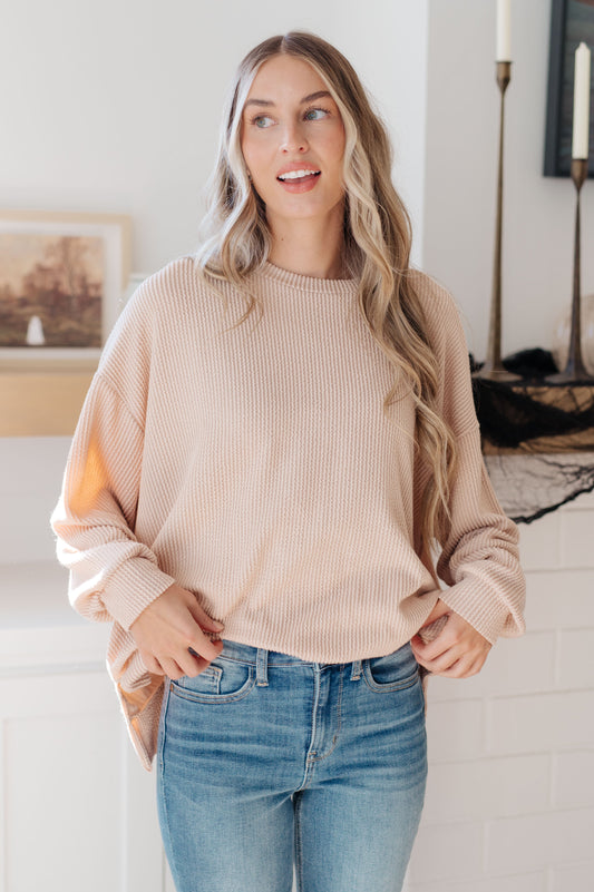 Woman wearing Holly Pullover in beige with crew neckline and relaxed fit.