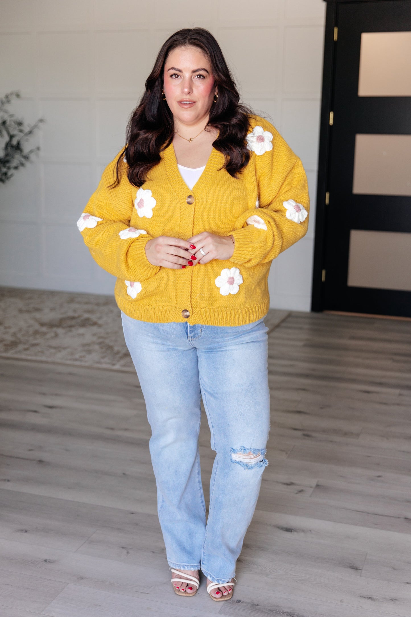 Yellow cardigan with white knit floral accents, V-neck, button front, long sleeves, and drop shoulders.