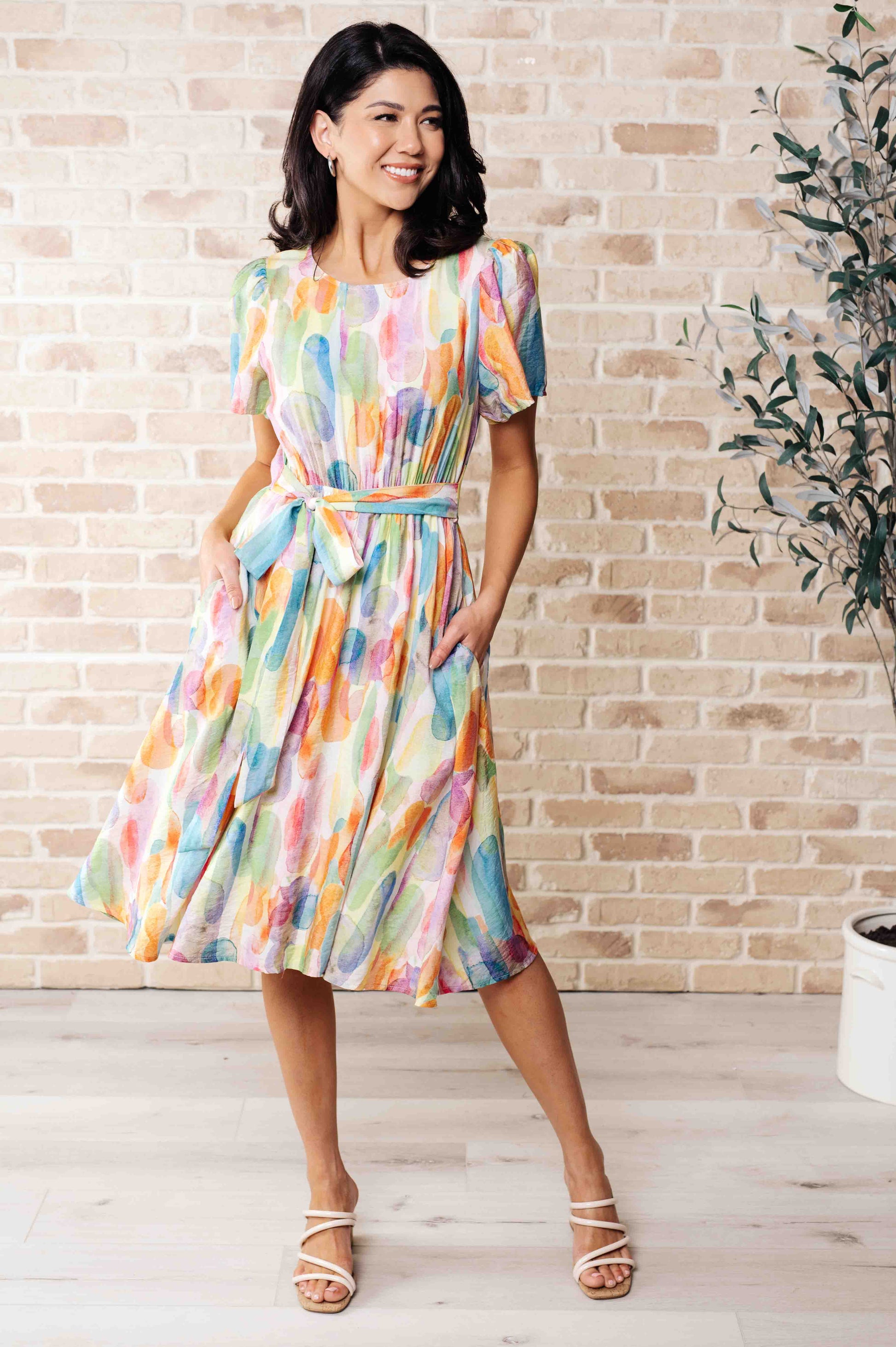 Yuna Midi Dress with a rounded neckline, gathered short sleeves, keyhole back detail, and a watercolor print for a casual yet chic style.