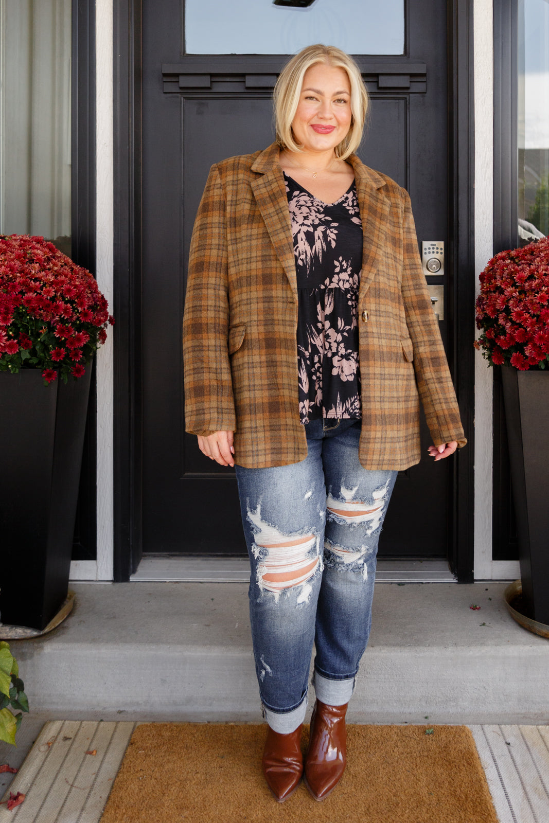 Brown plaid blazer with notched lapels, single button closure, and flap pockets. Features shoulder pads, a fully lined interior, and a tailored, relaxed fit.