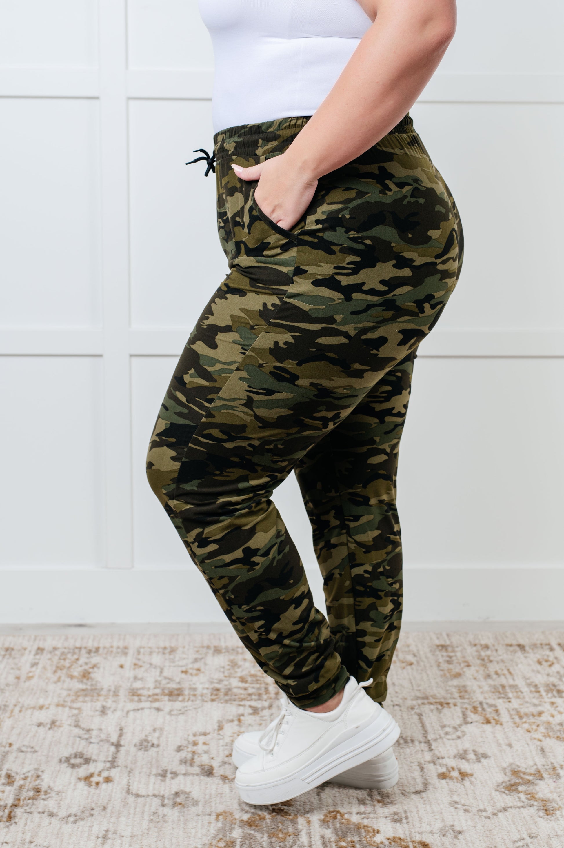 Women's joggers made from double-brushed microfiber with a camo print, featuring an elastic waistband, functional drawstring, and pockets.