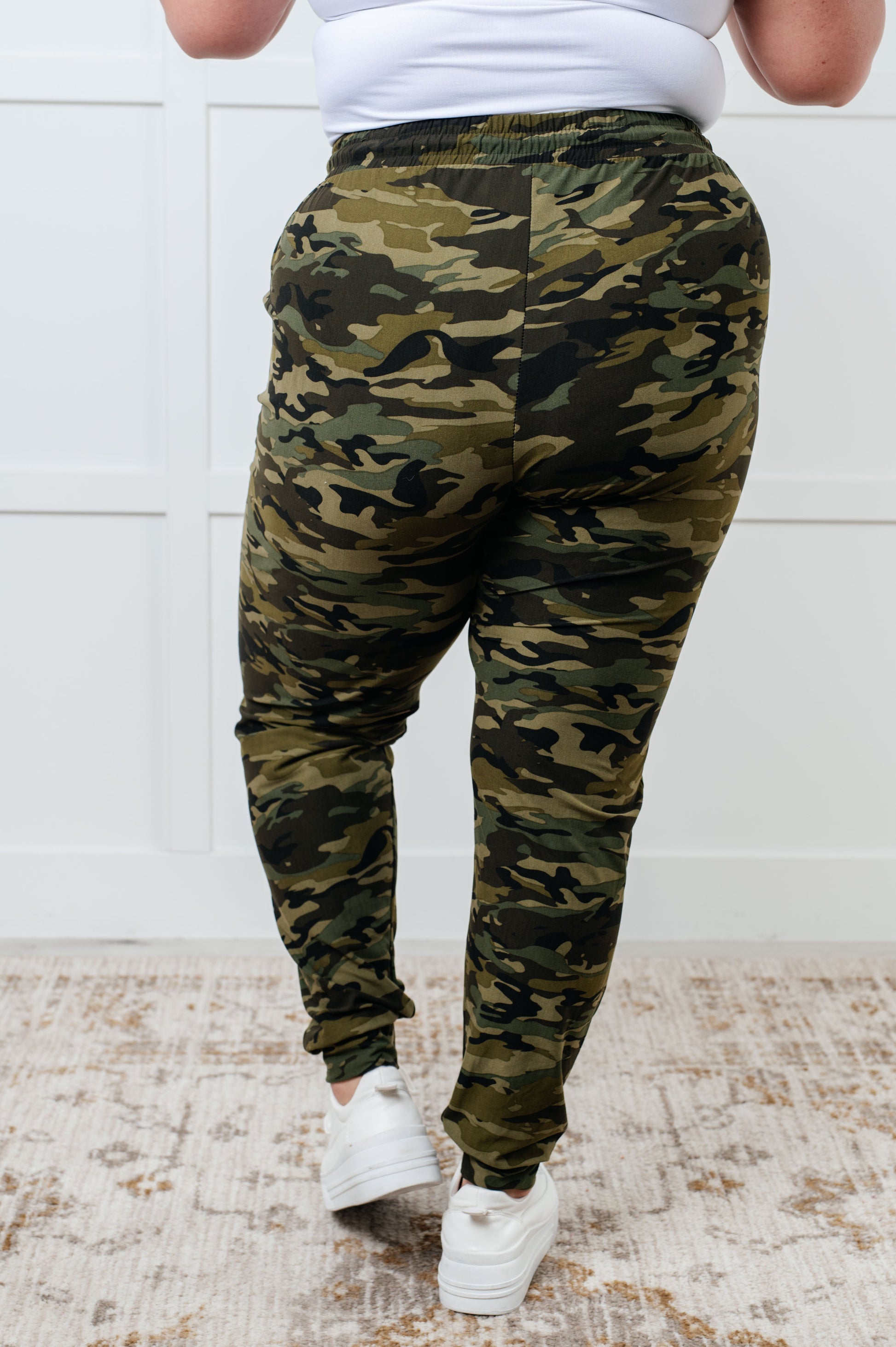 Women's joggers made from double-brushed microfiber with a camo print, featuring an elastic waistband, functional drawstring, and pockets.