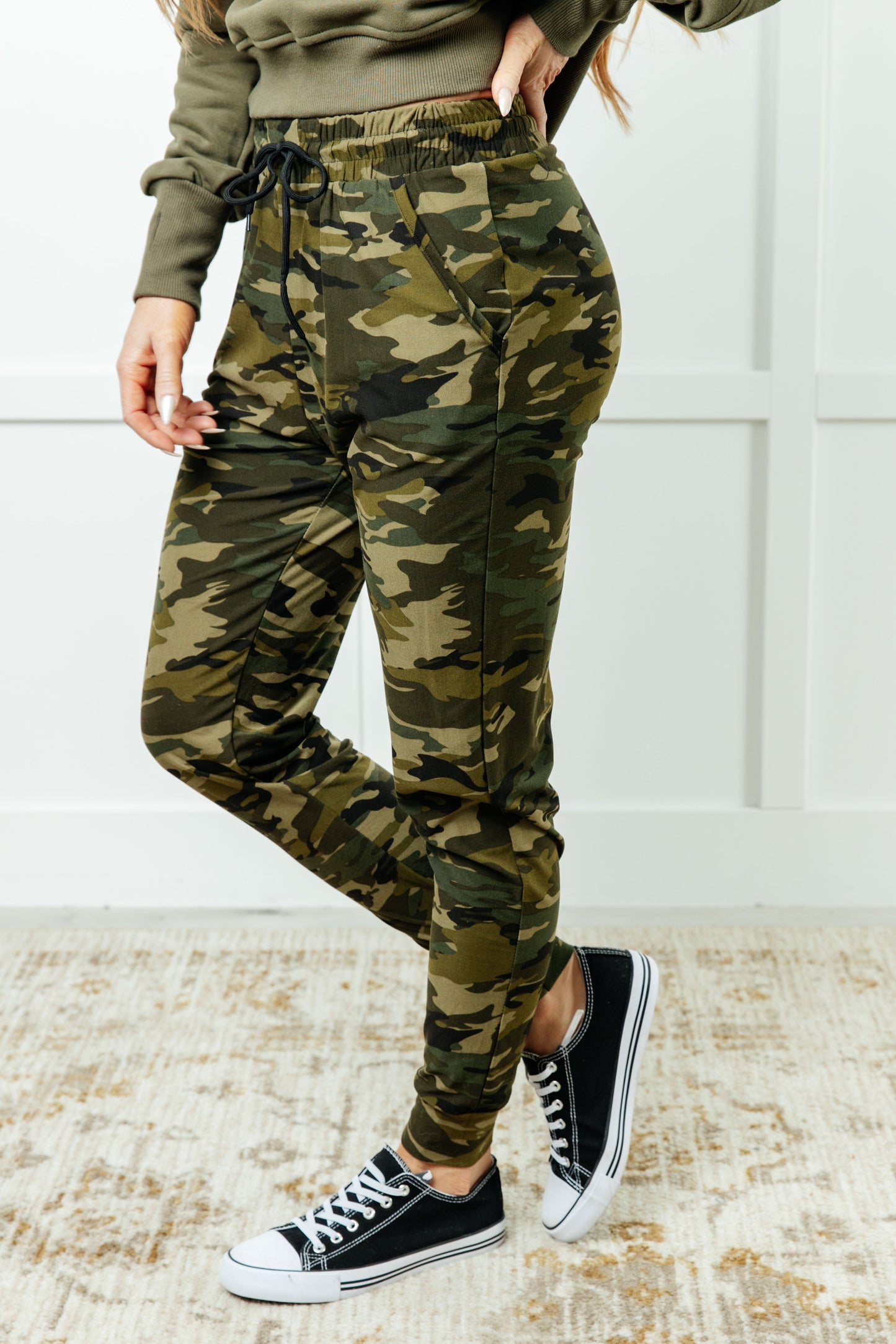 Women's joggers made from double-brushed microfiber with a camo print, featuring an elastic waistband, functional drawstring, and pockets.