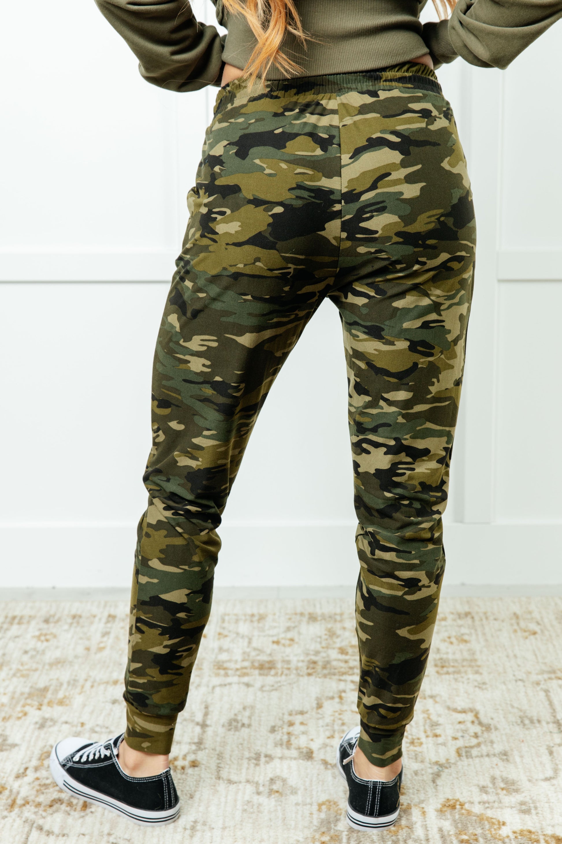 Women's joggers made from double-brushed microfiber with a camo print, featuring an elastic waistband, functional drawstring, and pockets.