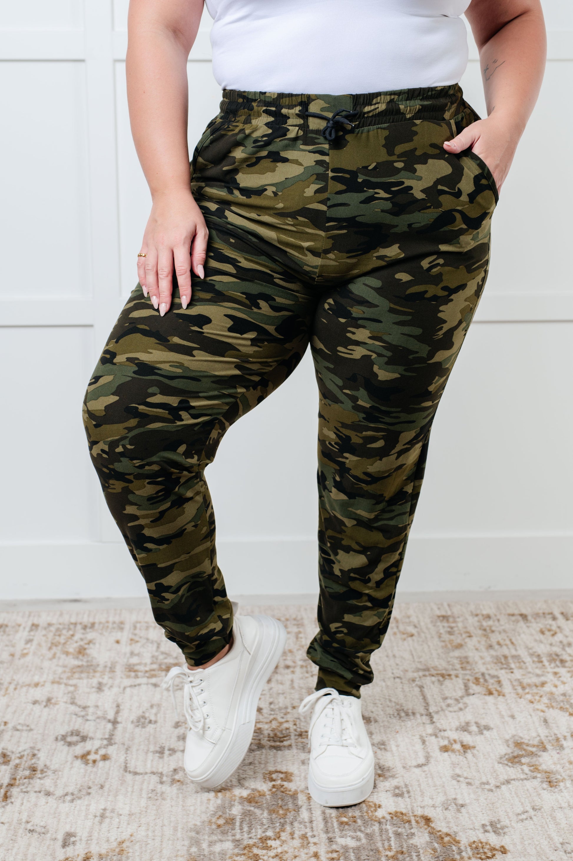 Women's joggers made from double-brushed microfiber with a camo print, featuring an elastic waistband, functional drawstring, and pockets.