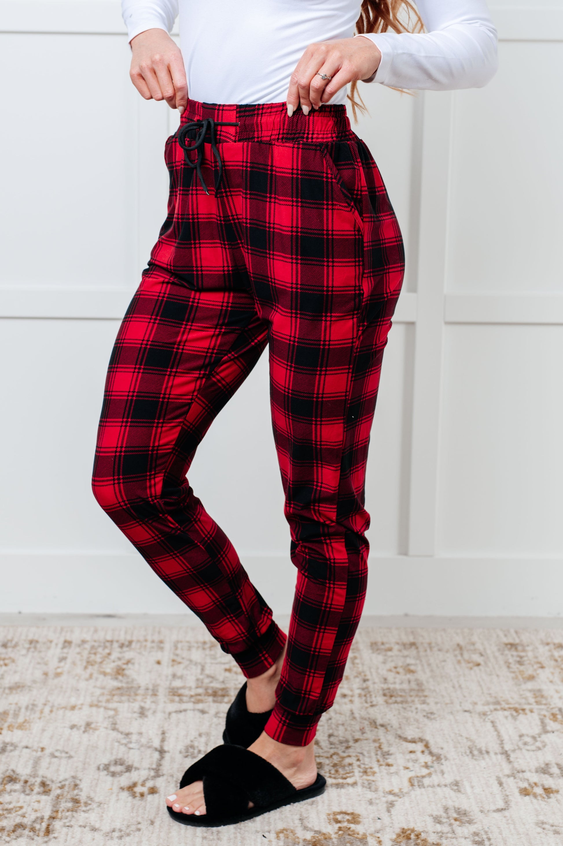 Women's joggers made from brushed microfiber in red plaid, featuring an elastic waistband, functional drawstring, and pockets.