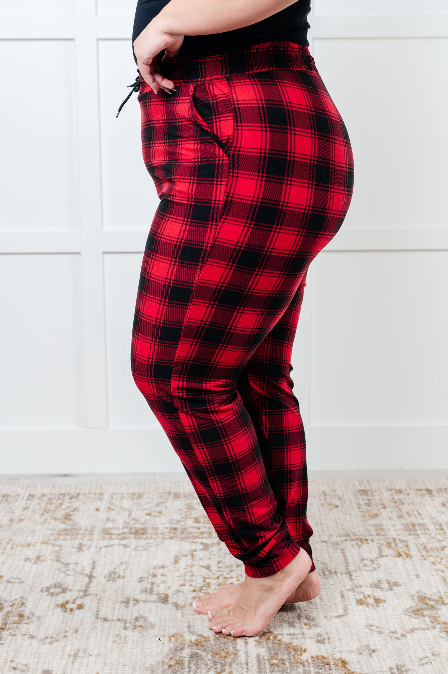 Women's joggers made from brushed microfiber in red plaid, featuring an elastic waistband, functional drawstring, and pockets.