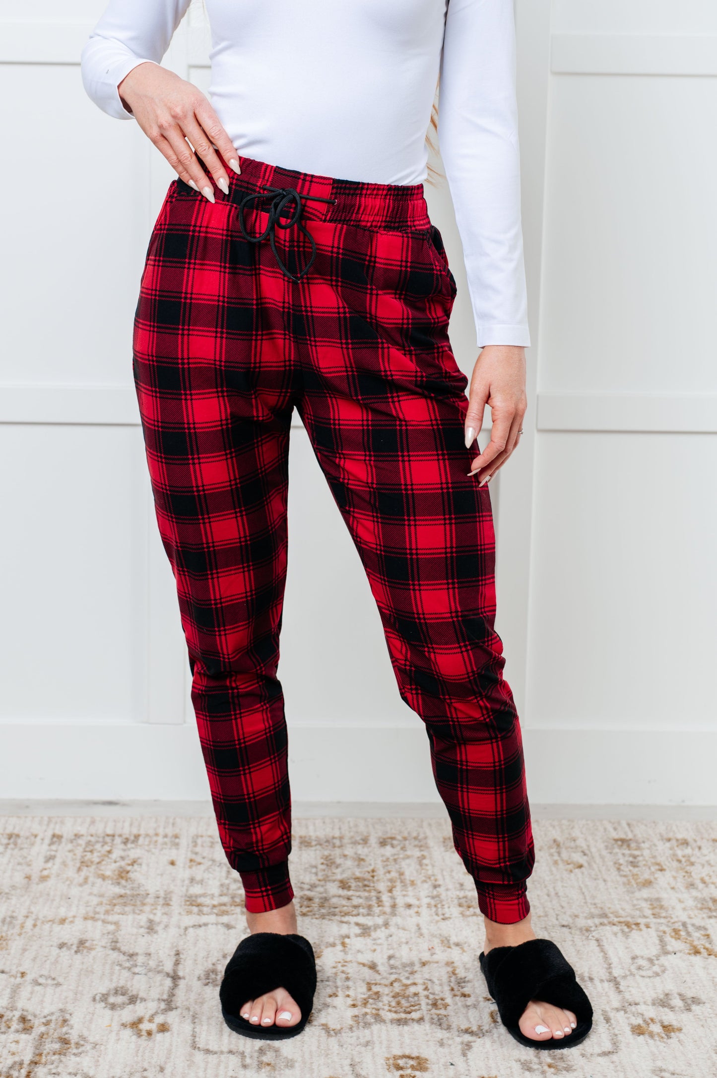 Women's joggers made from brushed microfiber in red plaid, featuring an elastic waistband, functional drawstring, and pockets.