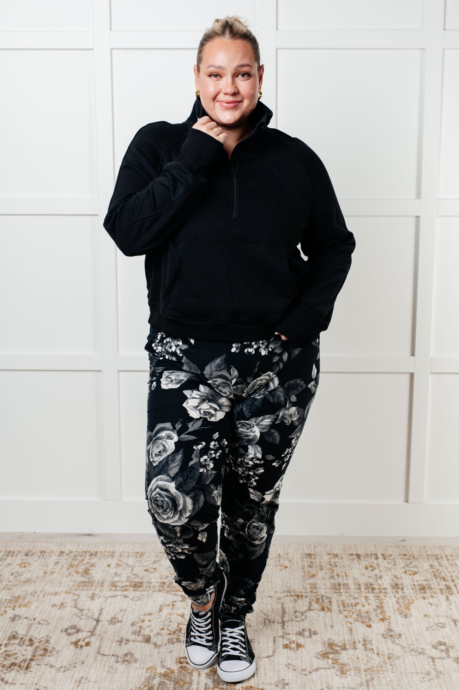 Women's joggers made from brushed microfiber in black with a white rose print, featuring an elastic waistband, functional drawstring, and pockets.