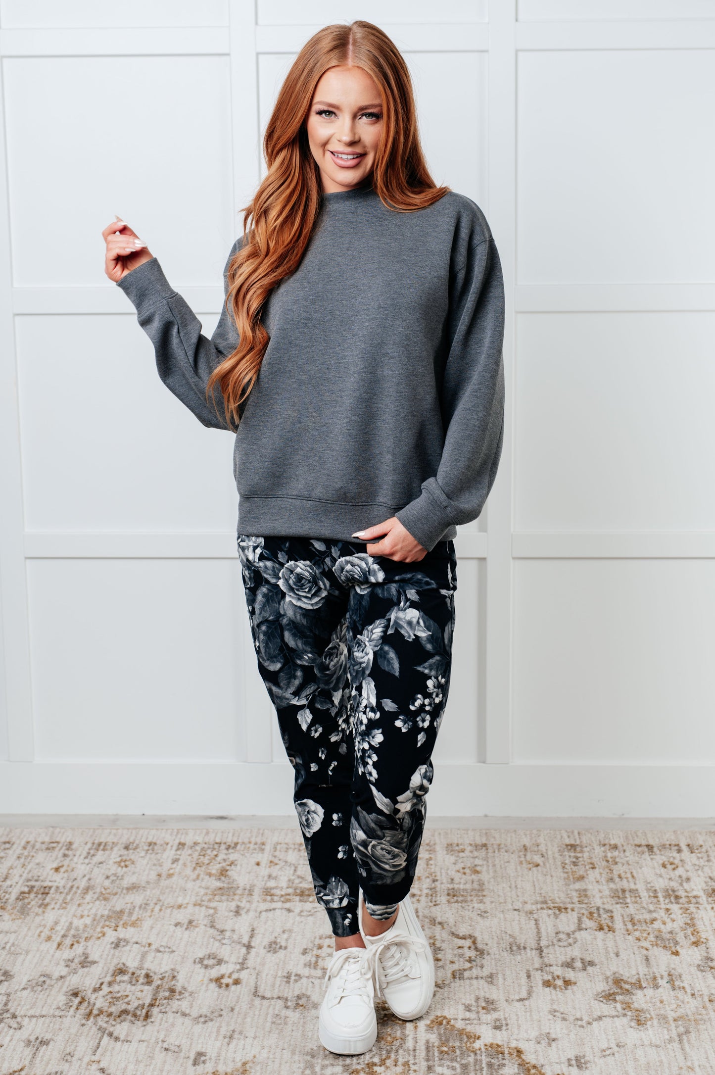 Women's joggers made from brushed microfiber in black with a white rose print, featuring an elastic waistband, functional drawstring, and pockets.