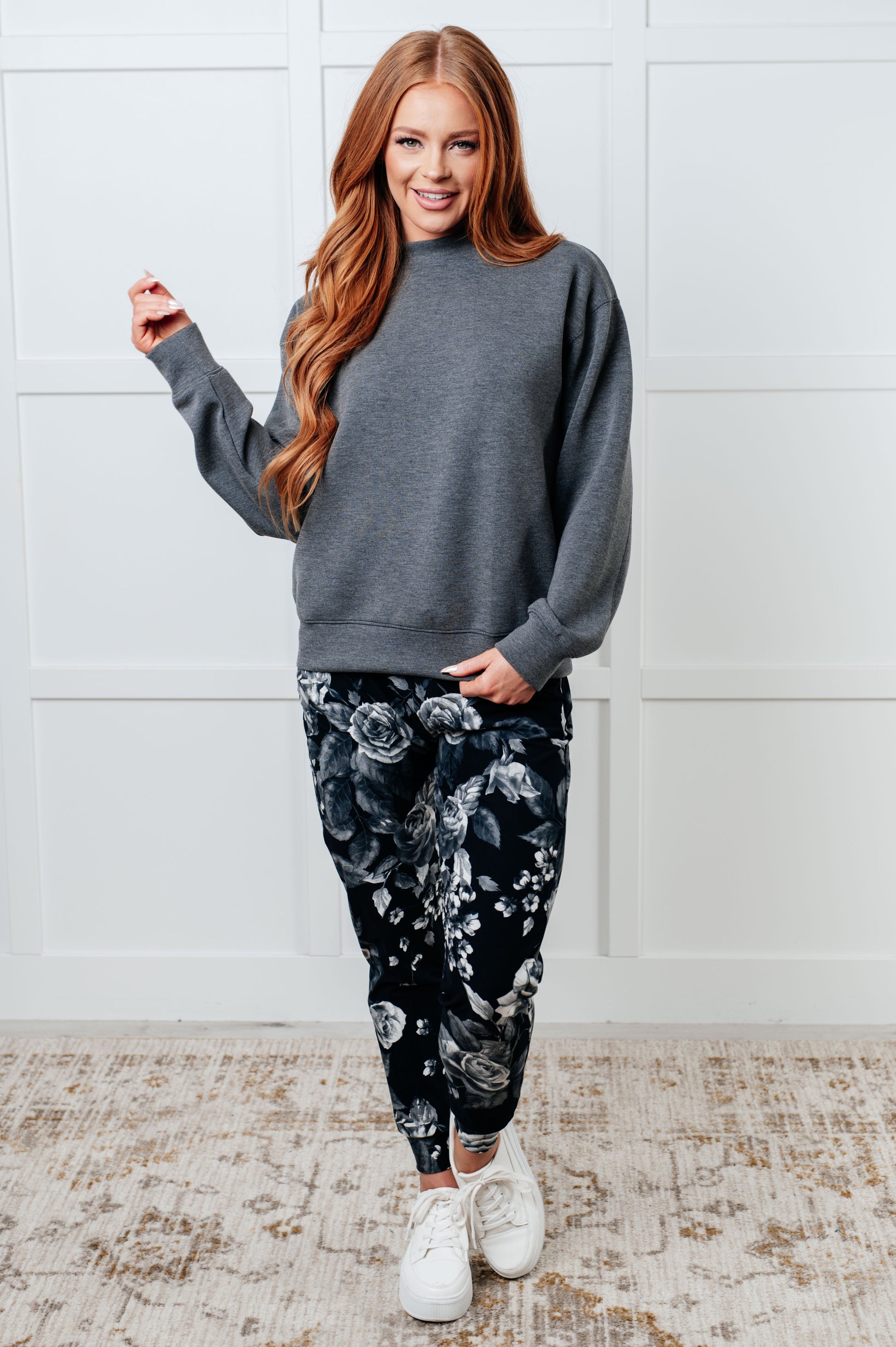 Women's joggers made from brushed microfiber in black with a white rose print, featuring an elastic waistband, functional drawstring, and pockets.