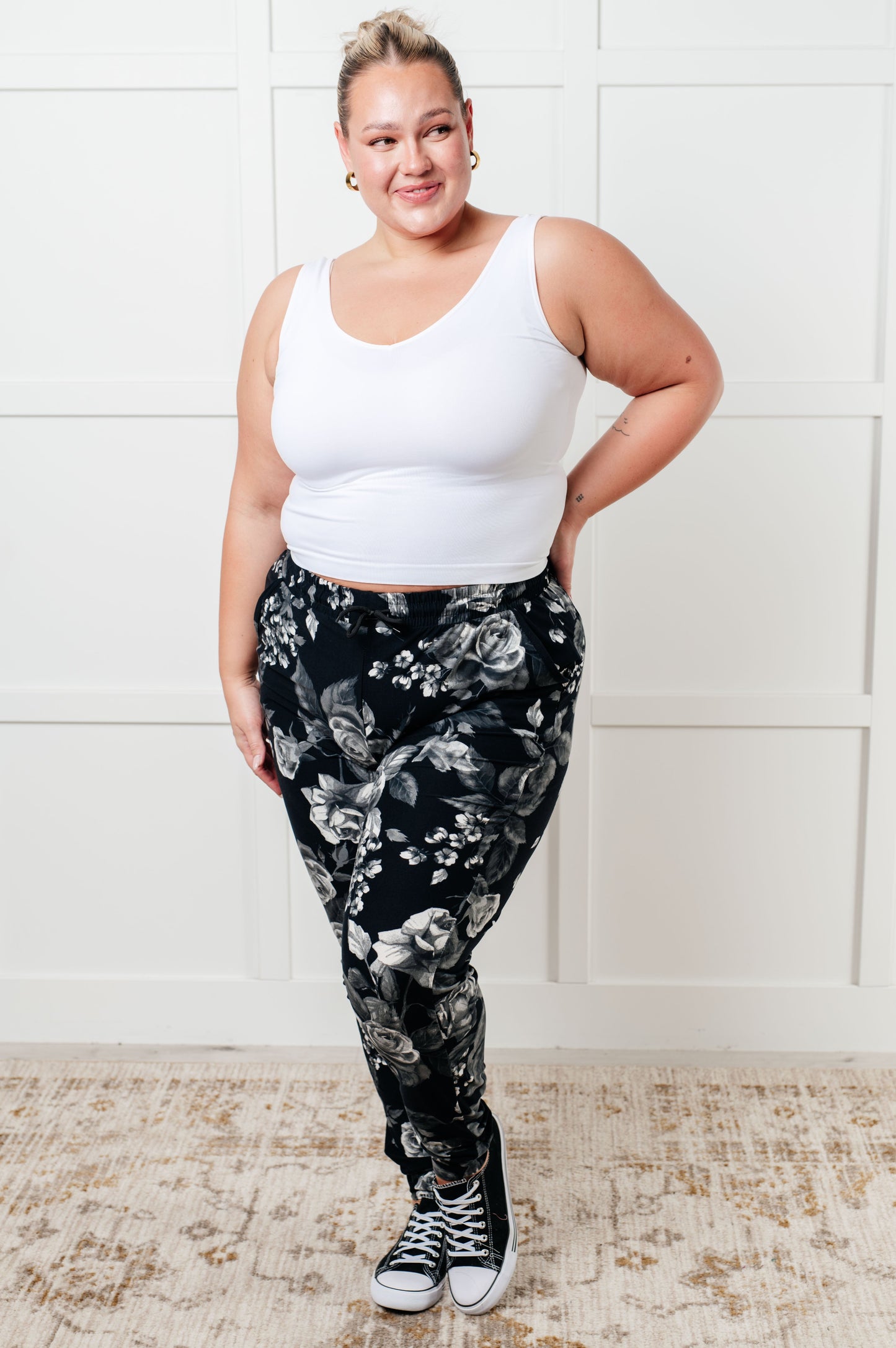 Women's joggers made from brushed microfiber in black with a white rose print, featuring an elastic waistband, functional drawstring, and pockets.