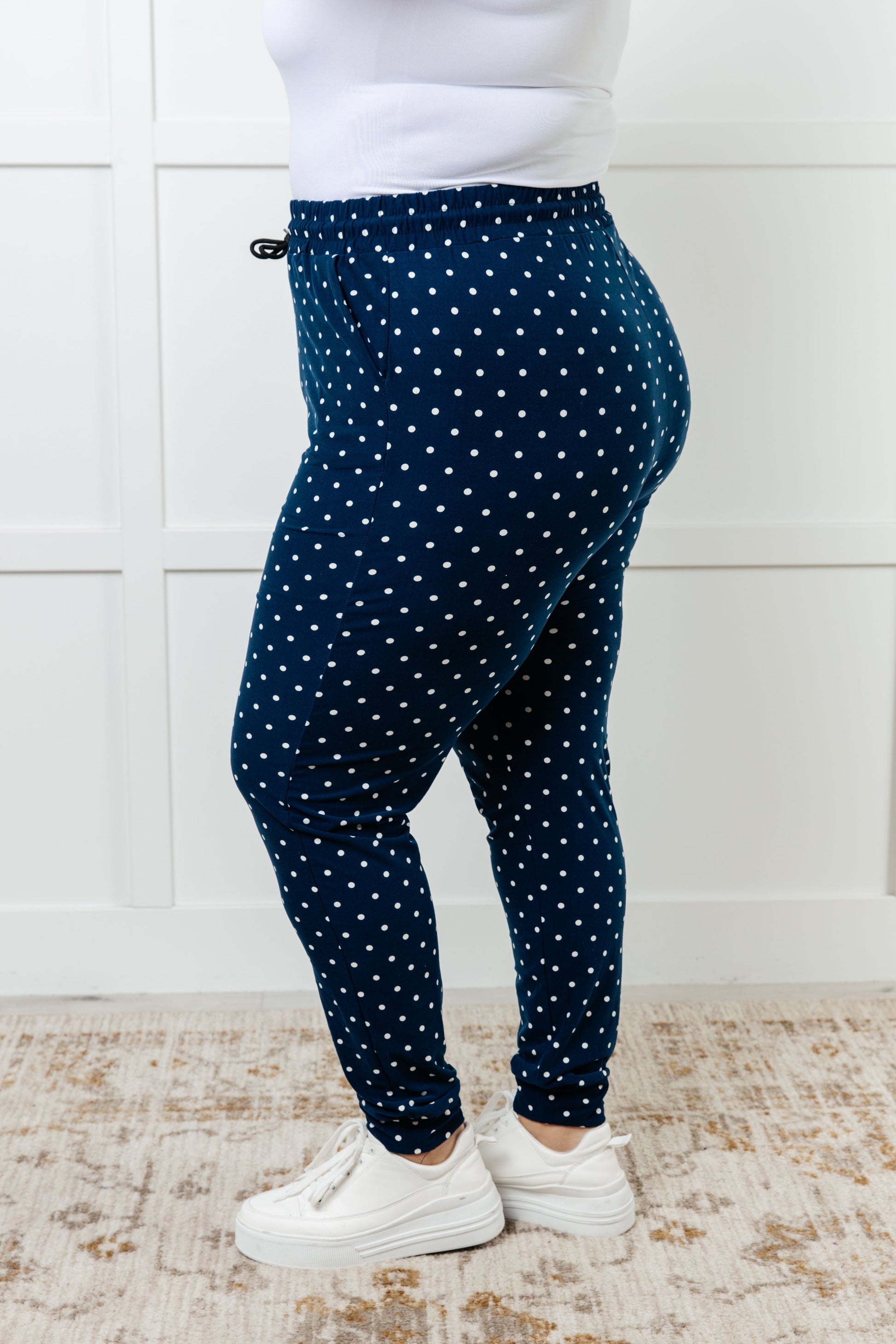 Women's joggers made from double-brushed microfiber in navy with a white polka-dot print, featuring an elastic waistband, functional drawstring, and pockets.