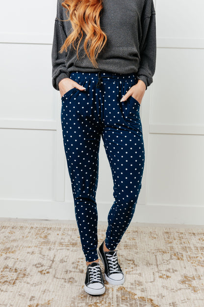Model wearing Merrick White Polka Dot Joggers, front view highlighting elastic waist and tapered legs.
