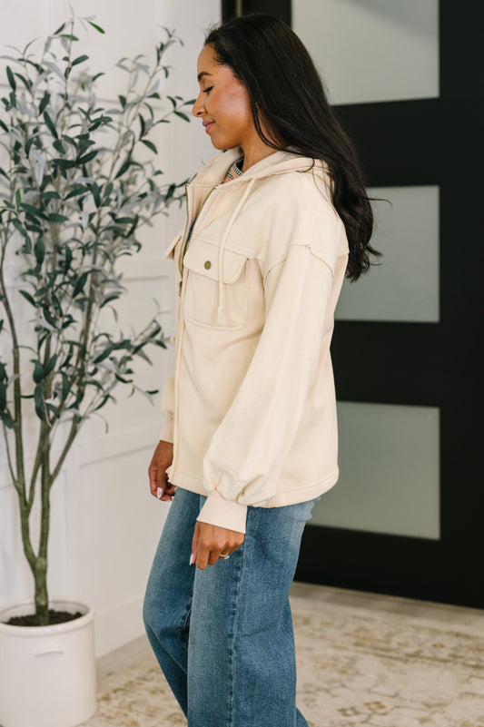 Side angle of Leona Hoodie in cream showing exposed seams and relaxed fit.