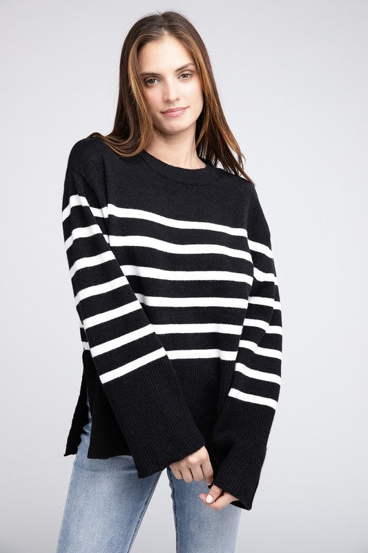 Black oversized sweater with a ribbed hem and striped pattern, featuring a round neckline and long sleeves.