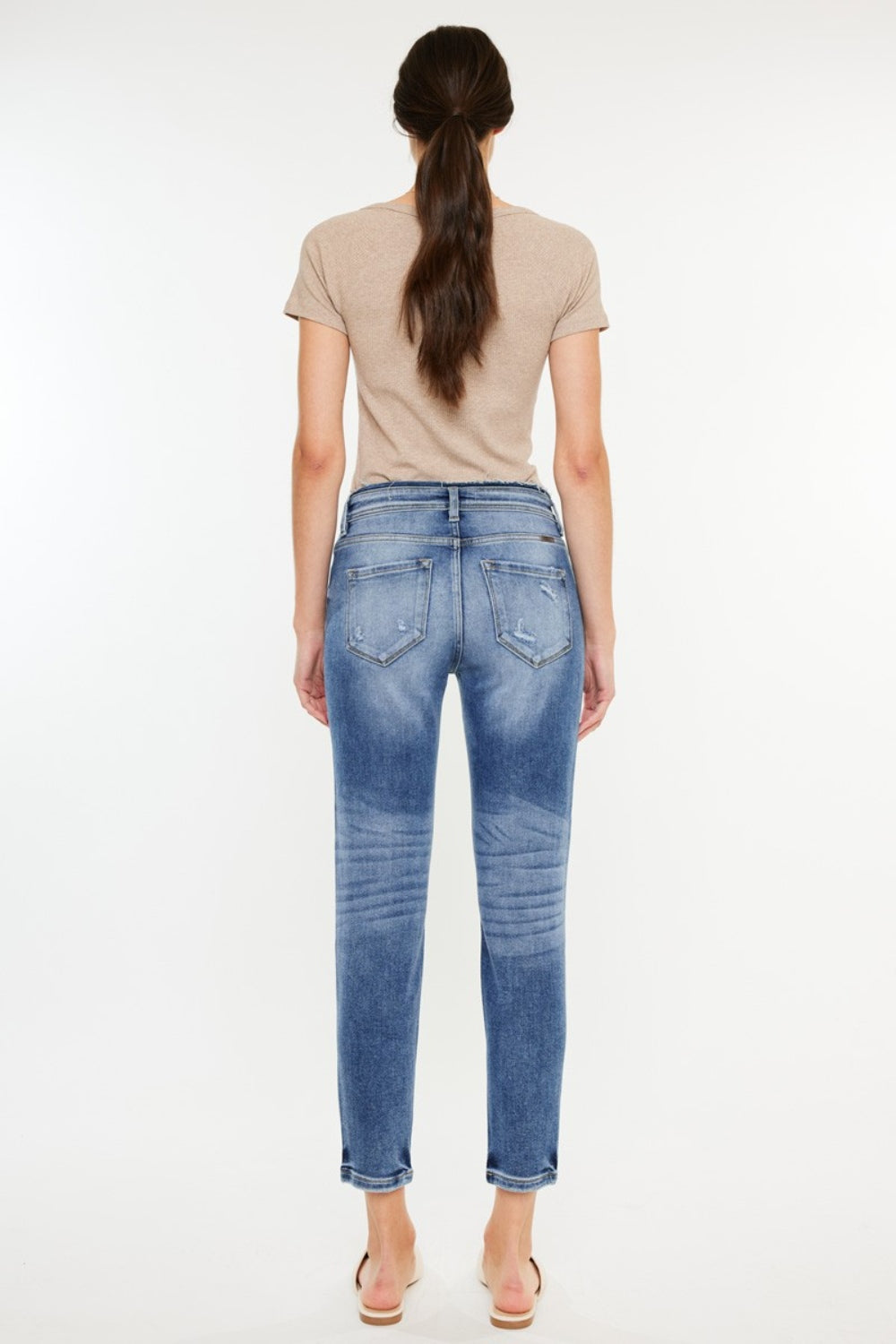 Medium wash high-rise mom jeans with distressed details and slightly stretchy fabric, offering a vintage-inspired, comfortable fit.