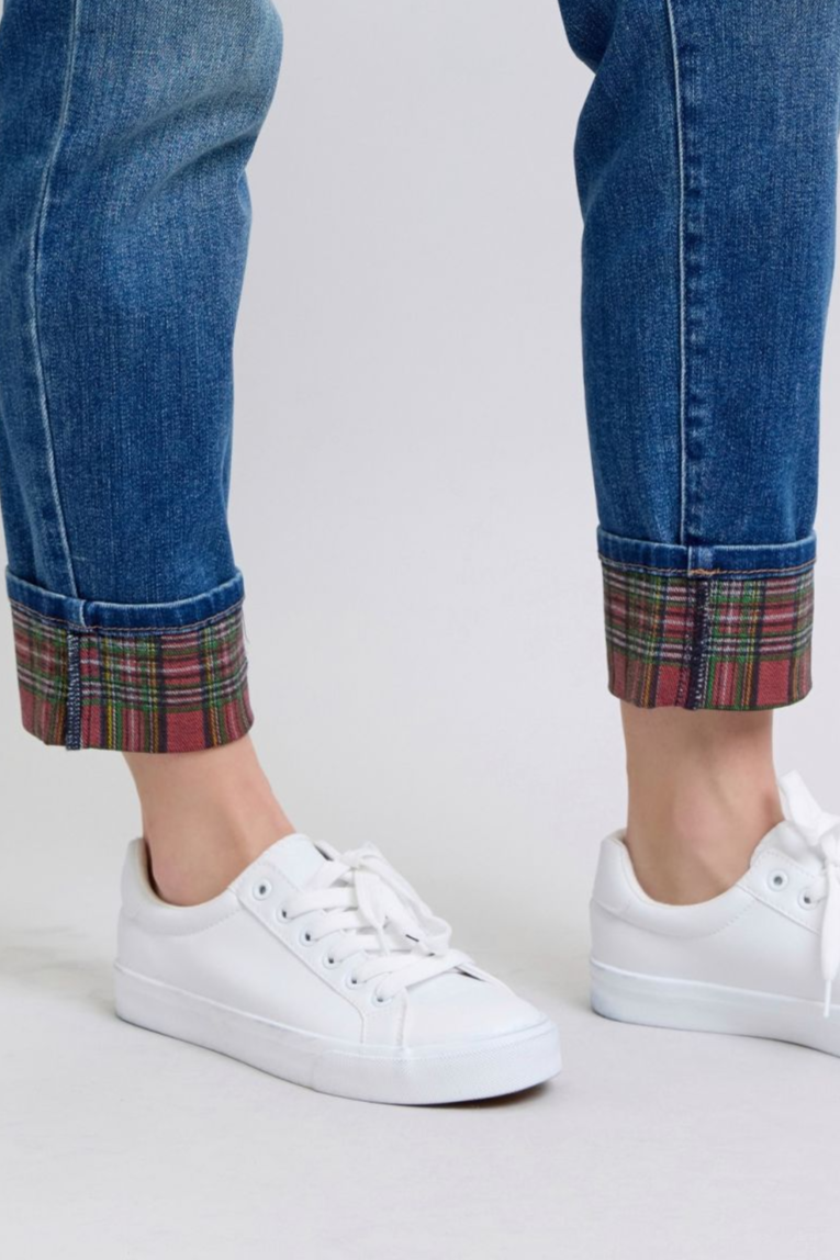 Women's mid rise, medium-wash straight-leg jeans with red and green plaid cuffs.