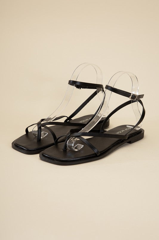 Black stylish strappy flat sandals with an open toe and square shape.