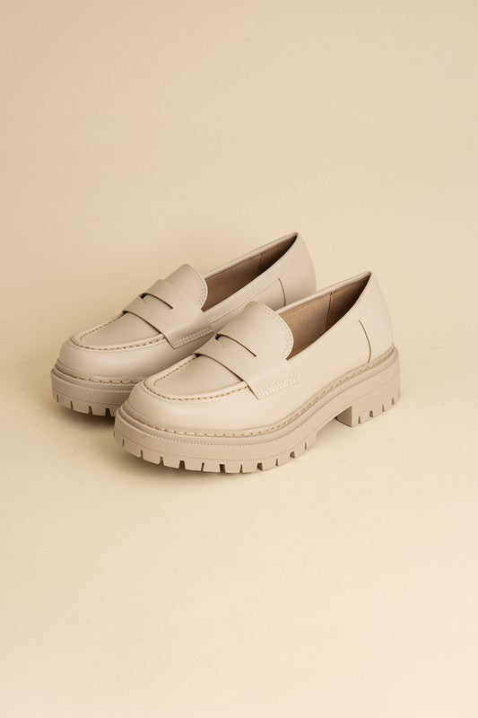 Bone classic loafers with a sleek design and minimalist accents.