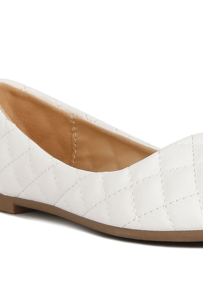 Close-up of quilted stitching on white ballet flats.