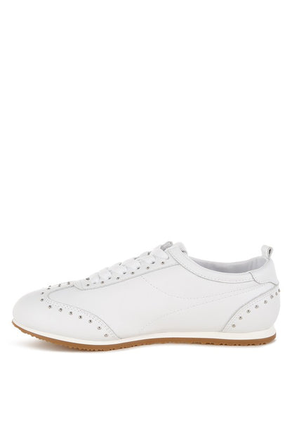 Side view of white Odaya Studded Leather Sneakers by Rag Company, showing stud embellishments, flatform sole, and lace-up design.