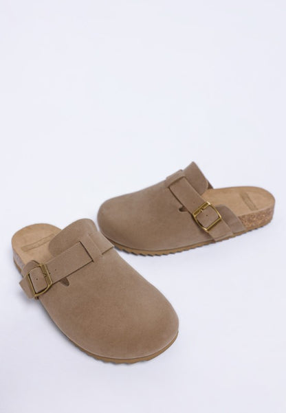 Pair of Taupe Ratiha Mules showing front and side view with buckle strap and subtle flat heel.
