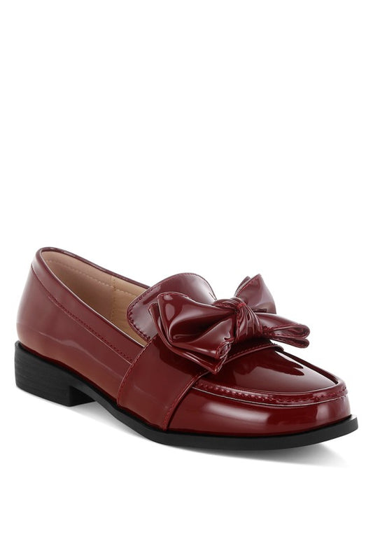 Front angle of Araminta Classic Chunky Bow Loafers in Burgundy faux leather with round toe