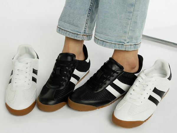 Model wearing black Blaster sneakers with white stripes, flanked by white Blaster sneakers on either side – sporty mesh lace-ups by Rag Company