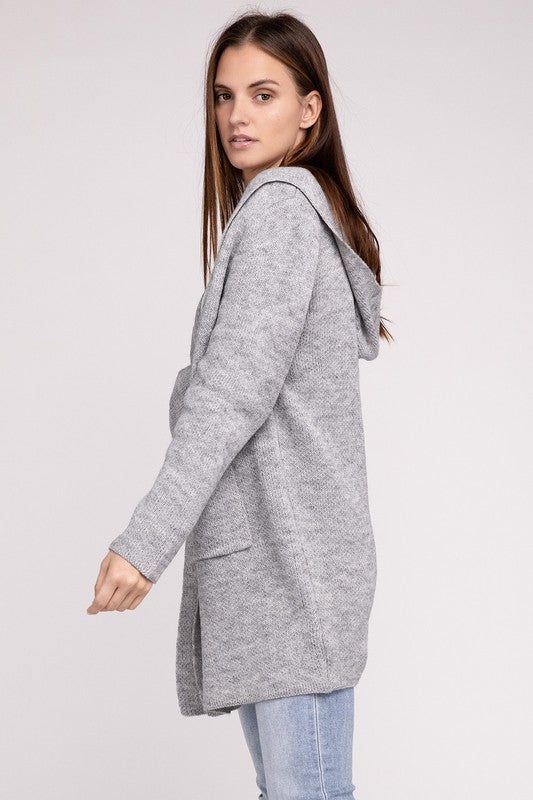 Grey sweater cardigan with long sleeves, front pockets, and a hooded neckline. 