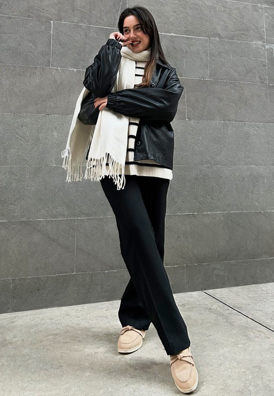 Woman wearing beige Nautica suede loafers styled with black pants and coat.
