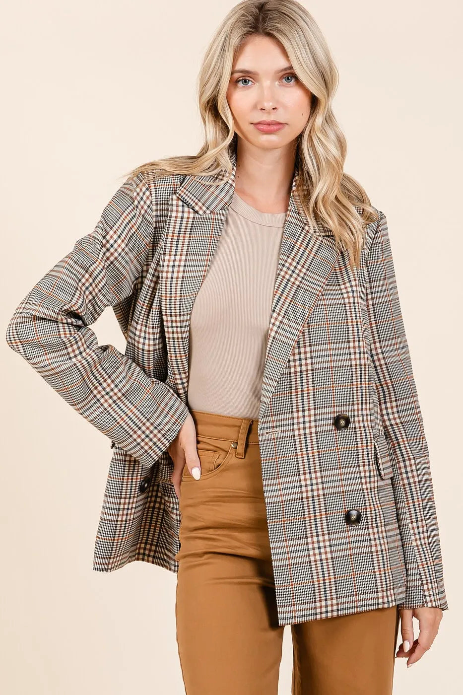 Front view of model wearing the Lennon Plaid Blazer unbuttoned with one hand on her hip, styled with brown jeans