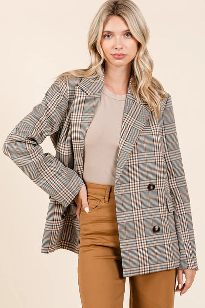 Front view of model wearing the Lennon Plaid Blazer unbuttoned with one hand on her hip, styled with brown jeans