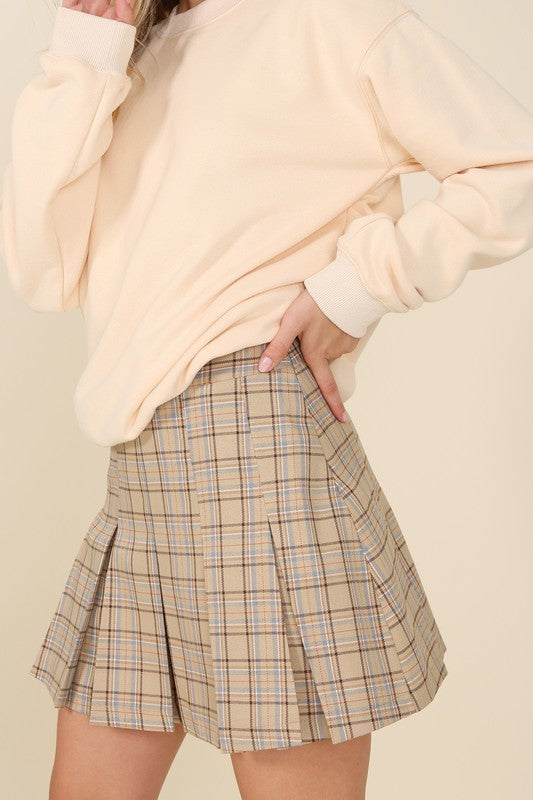 Tailored beige plaid mini skirt with pleats and six pin-tucks on both the front and back. Side zipper with a high waist.