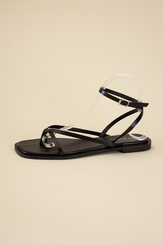 Black stylish strappy flat sandals with an open toe and square shape.