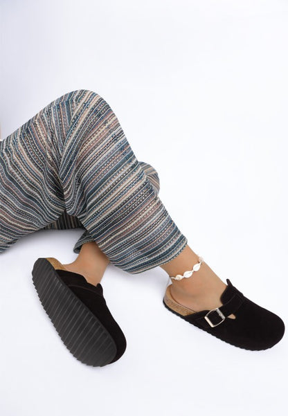 Model wearing Black Ratiha Mules top view showing cushioned footbed and tread sole design.