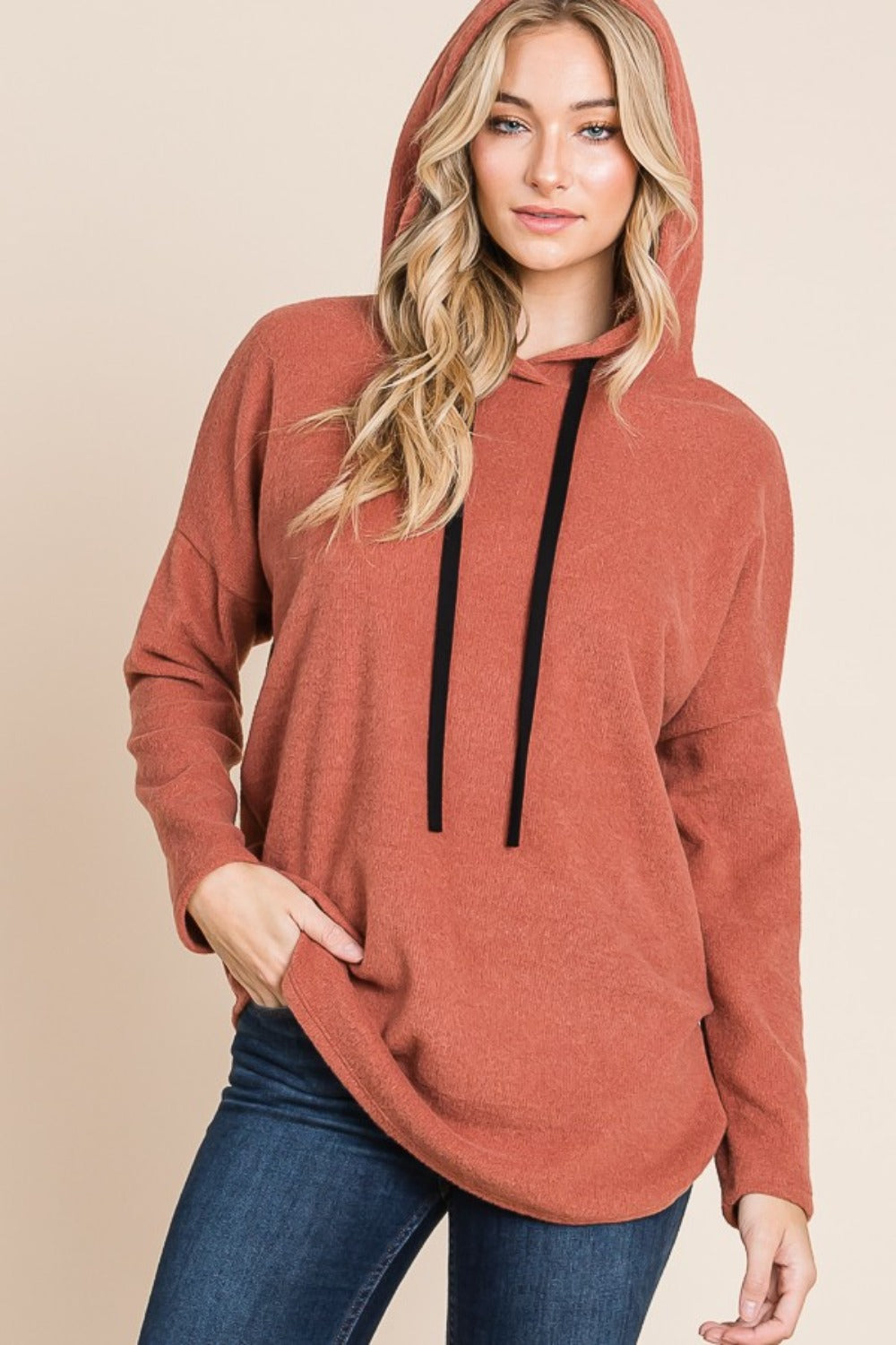 Warm brick hoodie with a black drawstring hood, long sleeves, and a relaxed fit. Features a soft brushed interior and dropped shoulders.