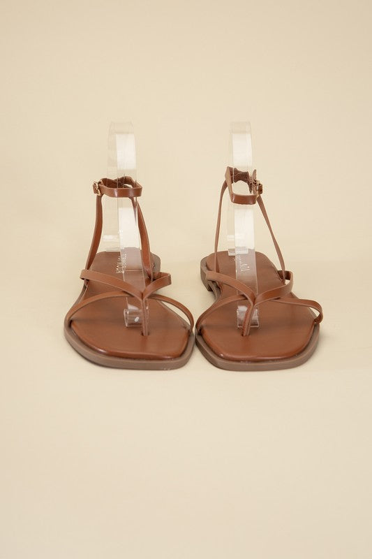 Tan stylish strappy flat sandals with an open toe and square shape.