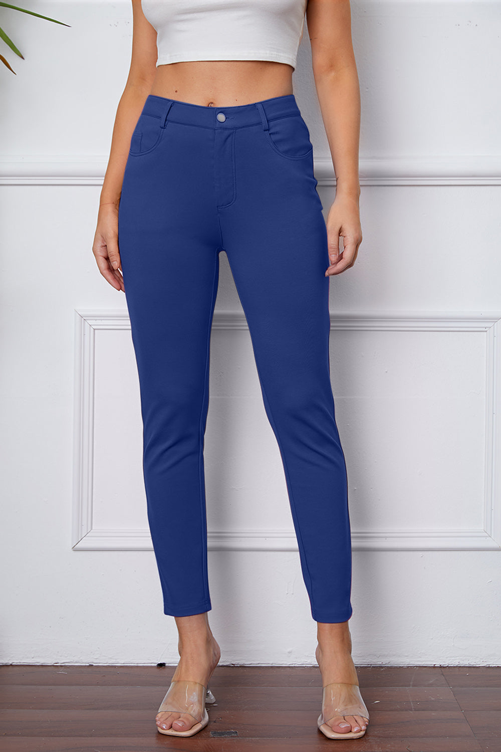 Royal blue stretchy high-waisted pants feature pockets, a zip fly, and belt loops. 